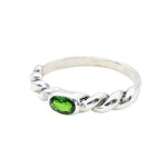 A twisted silver band with a vivid green gemstone, modern and artistic.