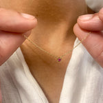 Woman holding her Real Ruby Necklace in Solid 14k Yellow Gold chain. A dainty minimalist July birthstone pendant symbolizing passion, and vitality. A small solitaire ruby necklace perfect for everyday wear, and even for special occasions. 