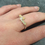 Dainty Fire Opal Cabochon Ring in bypass design worn on index finger with bare nails, glowing with fire colors, styled effortlessly with a black ribbed top, ideal for evening outings, birthday dinners, and festive events.