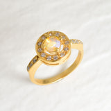 Ethiopian Opal diamond cut halo ring in gold, surrounded by sparkling CZ accents for brilliance and elegance. The halo design highlights flashes of fire colors while offering timeless durability. As the October Birthstone, Opal makes a meaningful gift for birthdays, engagements, anniversaries, or personal milestones. Perfect to wear at weddings, cocktail parties, and festive gatherings.
