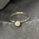 White Opal Bezel Ring with engraved tribal inspired silver band. The dainty minimalist design highlights the gemstone with flashes of color, making it both elegant and unique. Opal is known to bring inspiration, harmony, and emotional balance. A thoughtful promise ring or October birthstone gift for birthdays, anniversaries, and special milestones. Perfect to wear daily or for boho chic events, weddings, and family gatherings.