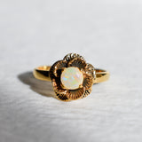 Vintage Fire Opal flower ring with a rose inspired artisan design in gold. The daisy style petals frame a round opal center for a floral and feminine look. Opal is believed to bring hope, creativity and emotional balance, making it a meaningful October birthstone gift. Perfect for weddings, anniversaries, special celebrations and romantic events.