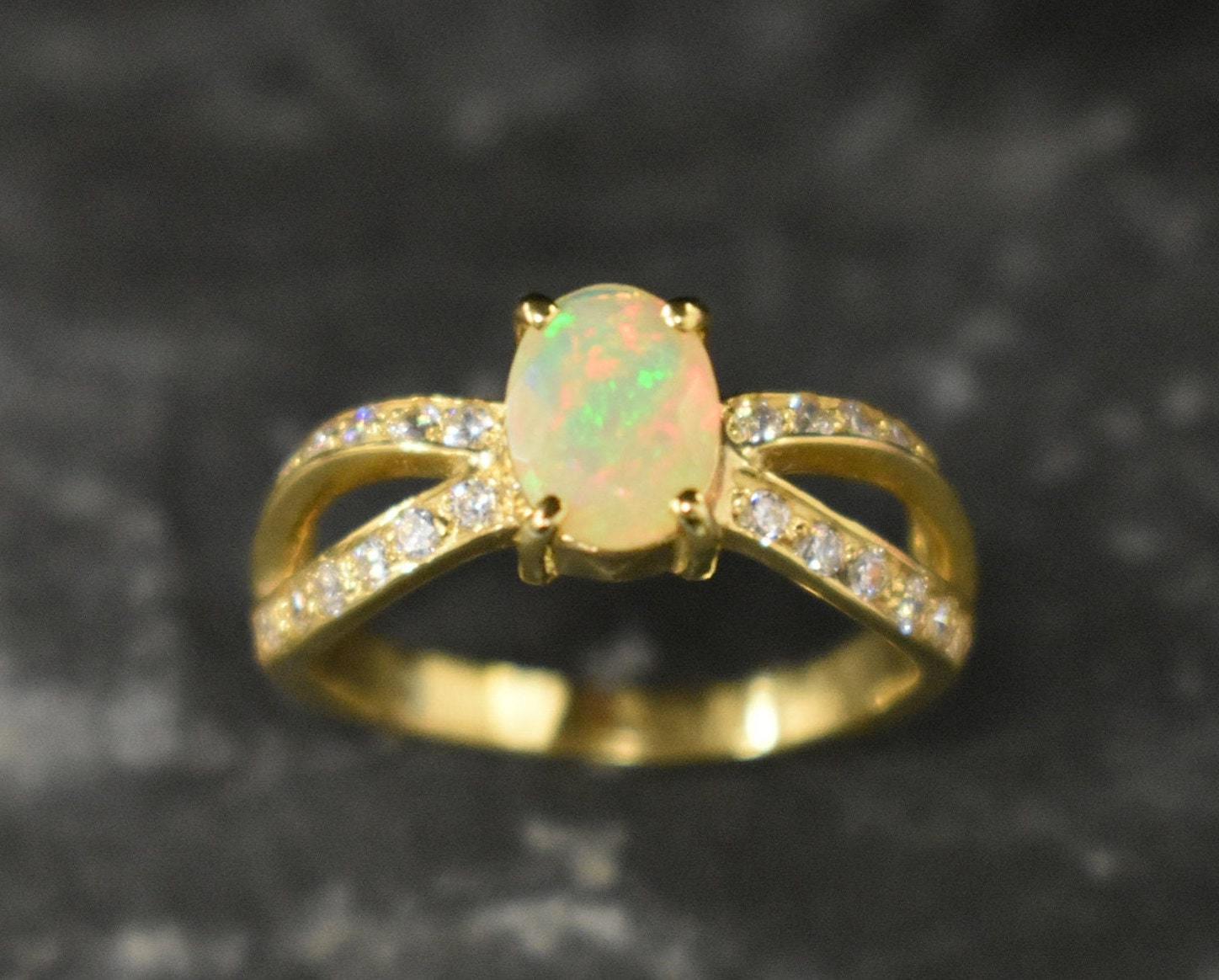 Opal Ring with split shank band and CZ pave setting showing flashes of fire colors, designed as elegant fine jewelry. Known for its emotional healing and creativity benefits, Opal is also the October birthstone and a thoughtful gift for birthdays or anniversaries. Perfect to wear at weddings, romantic dinners, and special evening celebrations.