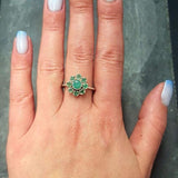 Emerald Flower Ring worn on middle finger with light blue gradient nails. The ring features a floral cluster of genuine emeralds in sterling silver. Emerald is the May birthstone linked to love, harmony, and renewal, making it a meaningful gift for birthdays, anniversaries, or promise occasions. Perfect to wear for weddings, family gatherings, and elegant parties.