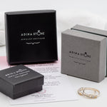 Opal Emerald Flower Ring worn on middle finger with light blue gradient nails. The opal shows flashes of fire colors surrounded by genuine emeralds in a floral cluster design. Perfect for adding inspiration and balance as an October birthstone and symbolizing love and growth as a May birthstone. Suitable for parties, birthdays, or casual outings.