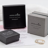 Opal Emerald Flower Ring worn on middle finger with light blue gradient nails. The opal shows flashes of fire colors surrounded by genuine emeralds in a floral cluster design. Perfect for adding inspiration and balance as an October birthstone and symbolizing love and growth as a May birthstone. Suitable for parties, birthdays, or casual outings.