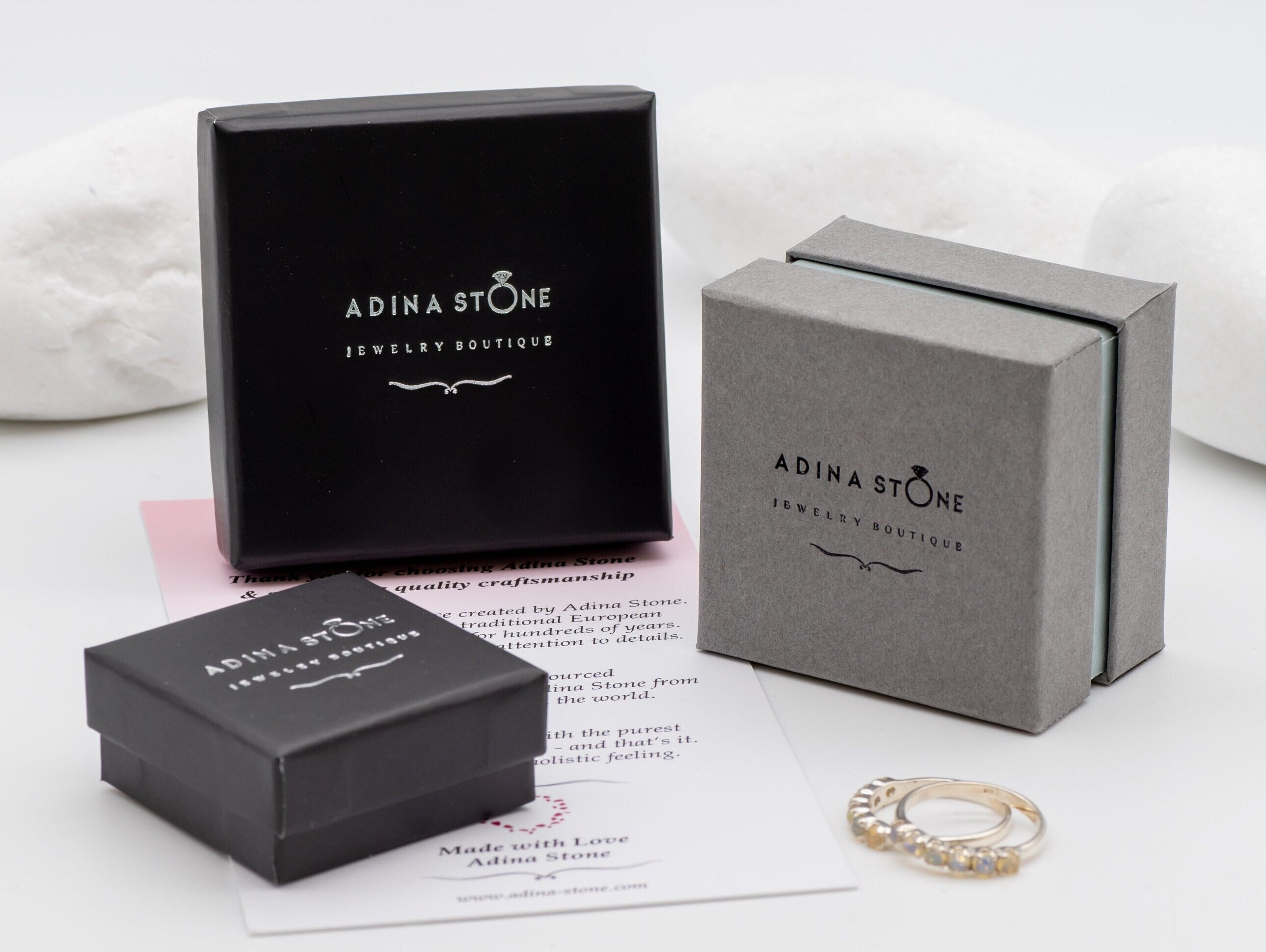 Opal Emerald Flower Ring worn on middle finger with light blue gradient nails. The opal shows flashes of fire colors surrounded by genuine emeralds in a floral cluster design. Perfect for adding inspiration and balance as an October birthstone and symbolizing love and growth as a May birthstone. Suitable for parties, birthdays, or casual outings.