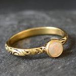 Bezel Opal ring with engraved gold band in a tribal boho style. The opal displays fire colors and flashing rainbow tones, symbolizing hope, creativity and emotional balance. A unique October birthstone gift perfect for anniversaries, festivals, weddings and special celebrations.