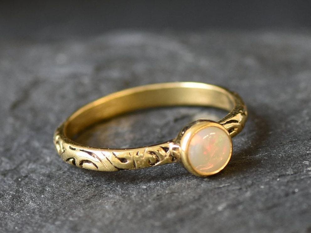 Bezel Opal ring with engraved gold band in a tribal boho style. The opal displays fire colors and flashing rainbow tones, symbolizing hope, creativity and emotional balance. A unique October birthstone gift perfect for anniversaries, festivals, weddings and special celebrations.