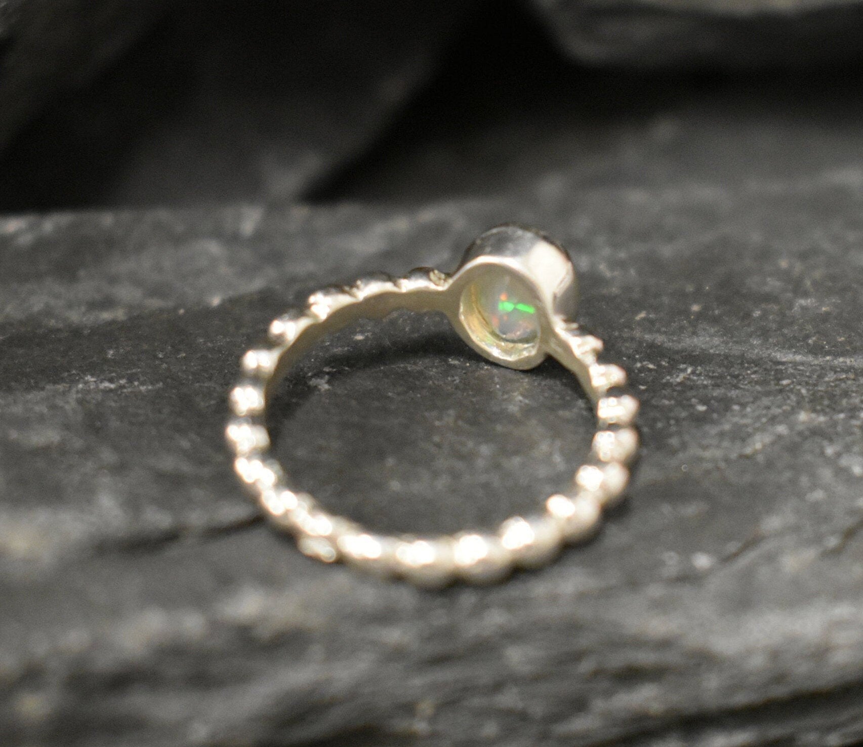 Fire Opal bezel bubble band ring in sterling silver with flashes of fire colors, a dainty jewelry style perfect for everyday elegance and stacking. Offers the benefit of durability with bezel setting and a glowing October birthstone gift idea for loved ones. Ideal to wear for birthdays, anniversaries, engagements, or casual celebrations.