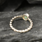 Fire Opal bezel bubble band ring in sterling silver with flashes of fire colors, a dainty jewelry style perfect for everyday elegance and stacking. Offers the benefit of durability with bezel setting and a glowing October birthstone gift idea for loved ones. Ideal to wear for birthdays, anniversaries, engagements, or casual celebrations.