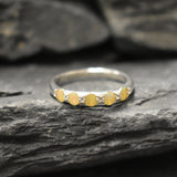 Yellow Ethiopian Fire Opal half eternity band ring in sterling silver with diamond cut stones set in a row, showcasing flashes of fire colors in a dainty jewelry style. Offers the benefit of a sleek eternity design with bright opals for durability and charm, making it a meaningful October birthstone gift. Perfect for weddings, anniversaries, birthdays, and daily wear.