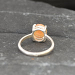 Ethiopian Fire Opal Solitaire Ring in sterling silver with a cabochon cut oval stone showing flashes of fire colors. Opal is linked to creativity, inspiration, and emotional balance, making it a meaningful October birthstone gift. A thoughtful choice for birthdays, anniversaries, promise rings, or engagements. Suitable for daily wear, weddings, and classic elegant occasions.