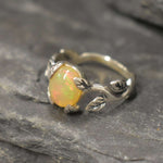 Opal Vine Ring in sterling silver with a cabochon cut gemstone framed by leaf and branch accents, a nature-inspired jewelry style that brings elegance and grounding energy with flashes of fire colors, making it a meaningful October birthstone gift idea. Perfect to wear at weddings, anniversaries, and outdoor celebrations for a radiant yet earthy look.