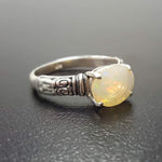 Ethiopian Fire Opal Sterling Silver Ring featuring a horizontal oval cut with a secure 4-prong setting. The engraved ornament band adds vintage charm, while the opal displays brilliant flashes of fire colors. A timeless October birthstone ring, perfect for birthdays, anniversaries, weddings, and milestone celebrations.