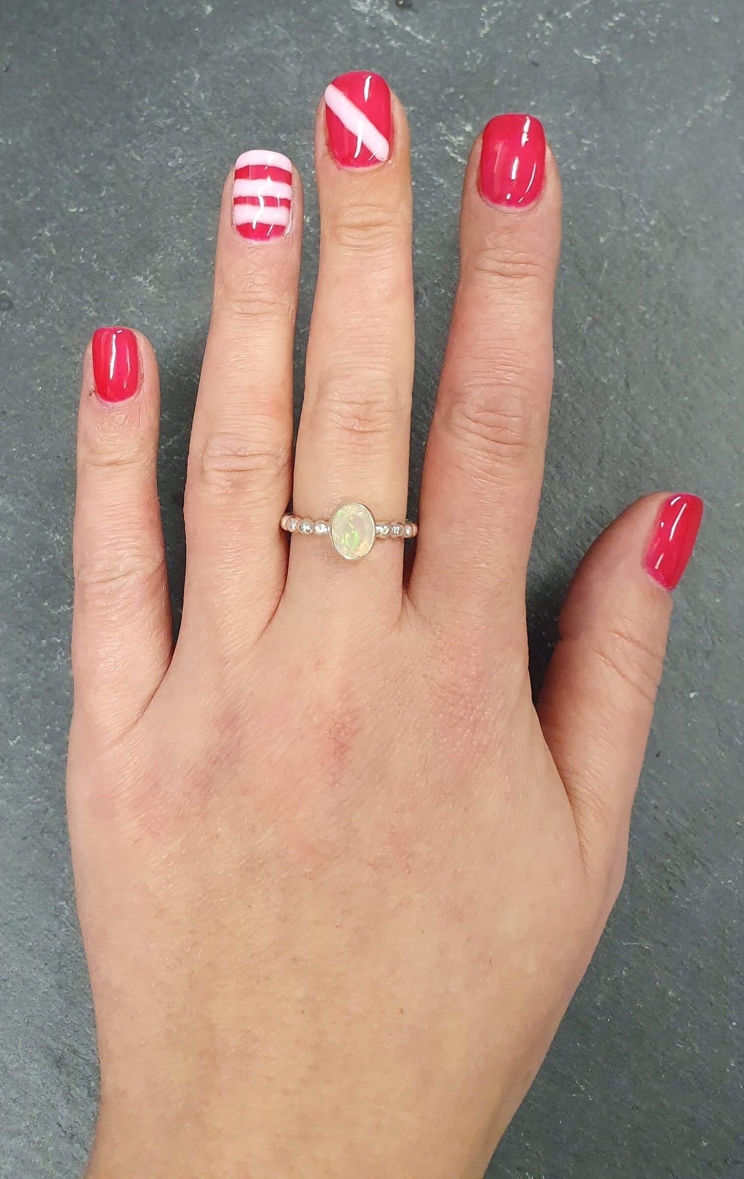 Fire Opal Bezel Ring showcased on hand with minimal nail art, tennis band design highlighting flashes of fire colors, brings confidence and balance as an October birthstone, perfect for coffee dates, daytime events, or casual dinners.