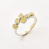 Fire Opal bypass ring in sterling silver with cabochon cut gemstones showcasing flashes of fire colors, crafted in a dainty jewelry style, believed to inspire joy and passion, a meaningful October birthstone gift idea for engagements, birthdays, and cocktail parties.