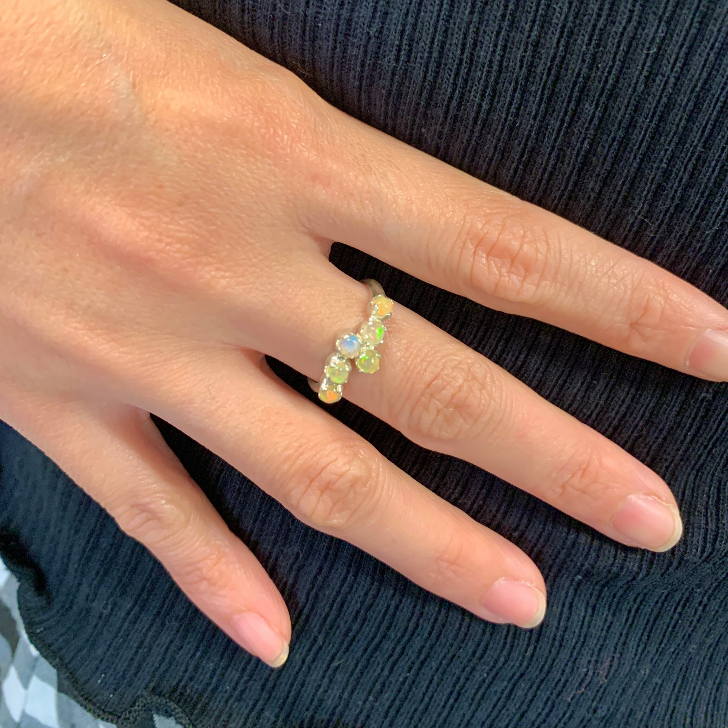 Fire Opal Bypass Cabochon Ring with flashes of fire colors worn on ring finger with nude nails, perfect for pairing with casual dresses or daily wear, symbolizing creativity and love, an ideal October birthstone accessory for brunches, date nights, and anniversaries.