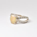 Natural Fire Opal diamond cut in a split sterling silver band with sparkling CZ Diamond accents offering vibrant energy and charm perfect as an October birthstone gift for engagements anniversaries or special celebrations.