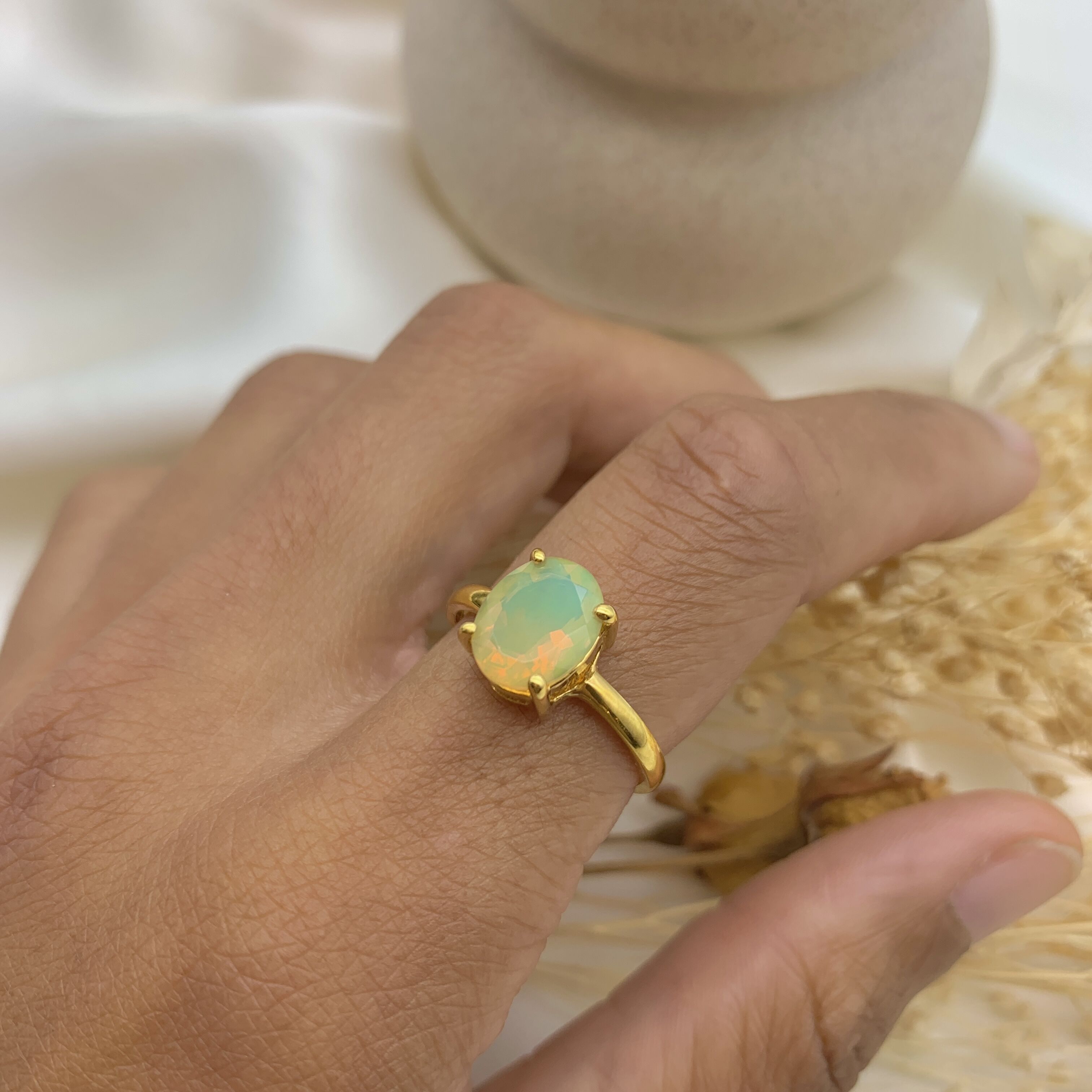 Fire Opal Gold Ring worn on index finger with bare nails perfect for adding warmth and confidence ideal for romantic dinners or autumn celebrations.