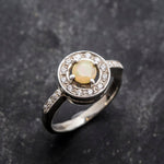 Ethiopian Opal diamond cut halo ring in solid 925 sterling silver, surrounded by sparkling CZ accents for brilliance and elegance. The halo design highlights flashes of fire colors while offering timeless durability. As the October Birthstone, Opal makes a meaningful gift for birthdays, engagements, anniversaries, or personal milestones. Perfect to wear at weddings, cocktail parties, and festive gatherings.
