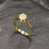 Natural Fire Opal Solitaire Ring in gold with a round cut stone held in a secure setting. The opal glows with flashes of fire colors, making it a timeless choice for a dainty promise ring or engagement ring. Fire Opal, the October birthstone, is believed to bring passion, inspiration, and joy. A meaningful gift for birthdays, anniversaries, and special milestones. Perfect for weddings, engagements, family gatherings, or everyday wear.