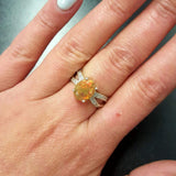 Opal Oval Ring worn on middle finger with natural nails. Jewelry style is bold and refined with a split shank band and 4 prong setting. The gemstone shows flashes of fire colors with added sparkle from the CZ pave band. Brings creativity, inspiration, and balance. A thoughtful birthstone gift for October birthdays and anniversaries. Ideal for weddings, family gatherings, and formal dinners.
