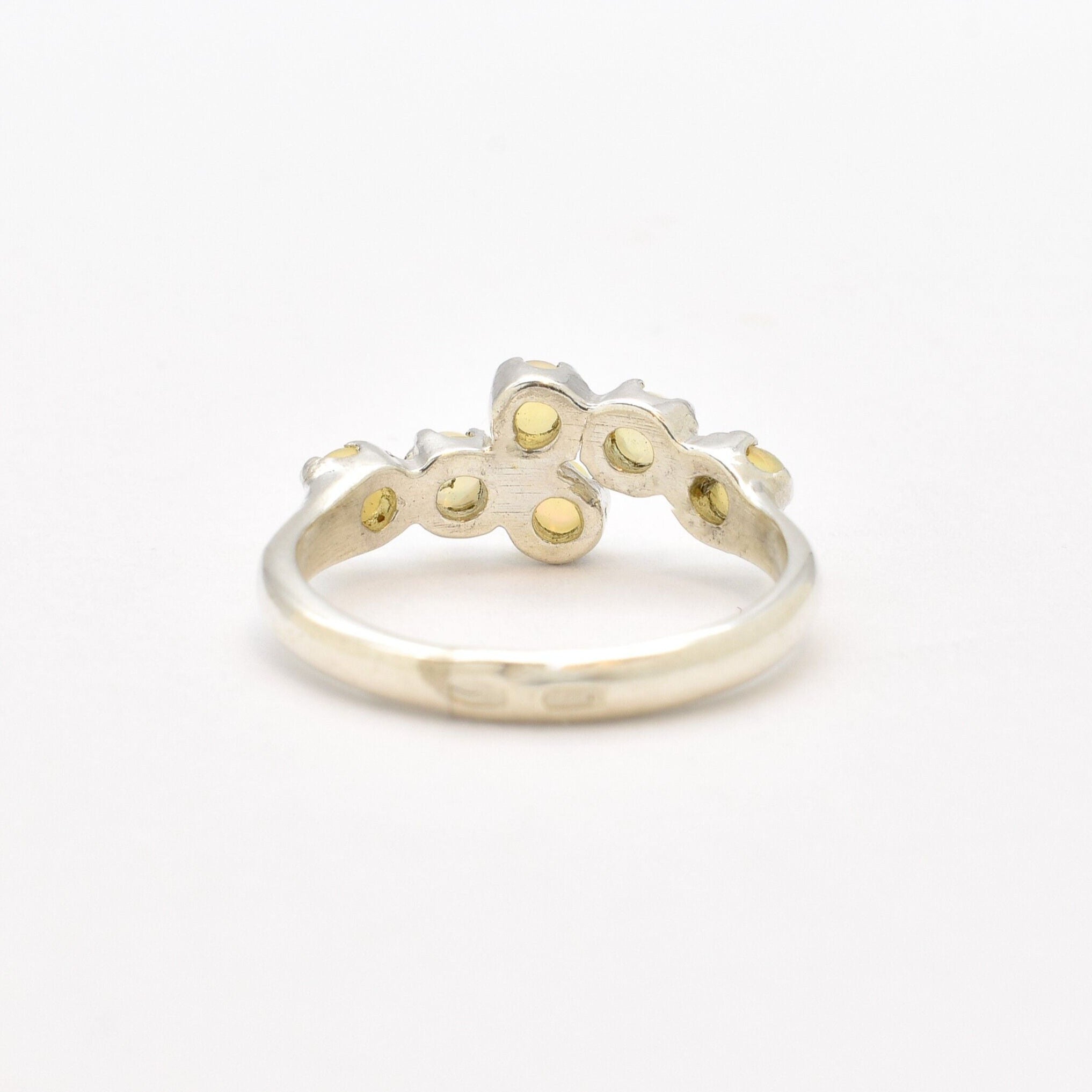 Fire Opal bypass ring in sterling silver with cabochon cut gemstones showcasing flashes of fire colors, crafted in a dainty jewelry style, believed to inspire joy and passion, a meaningful October birthstone gift idea for engagements, birthdays, and cocktail parties.