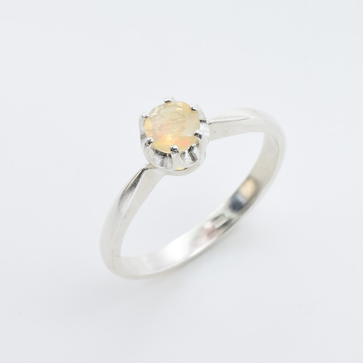 Natural Fire Opal Solitaire Ring in sterling silver with a round cut stone held in a secure setting. The opal glows with flashes of fire colors, making it a timeless choice for a dainty promise ring or engagement ring. Fire Opal, the October birthstone, is believed to bring passion, inspiration, and joy. A meaningful gift for birthdays, anniversaries, and special milestones. Perfect for weddings, engagements, family gatherings, or everyday wear.