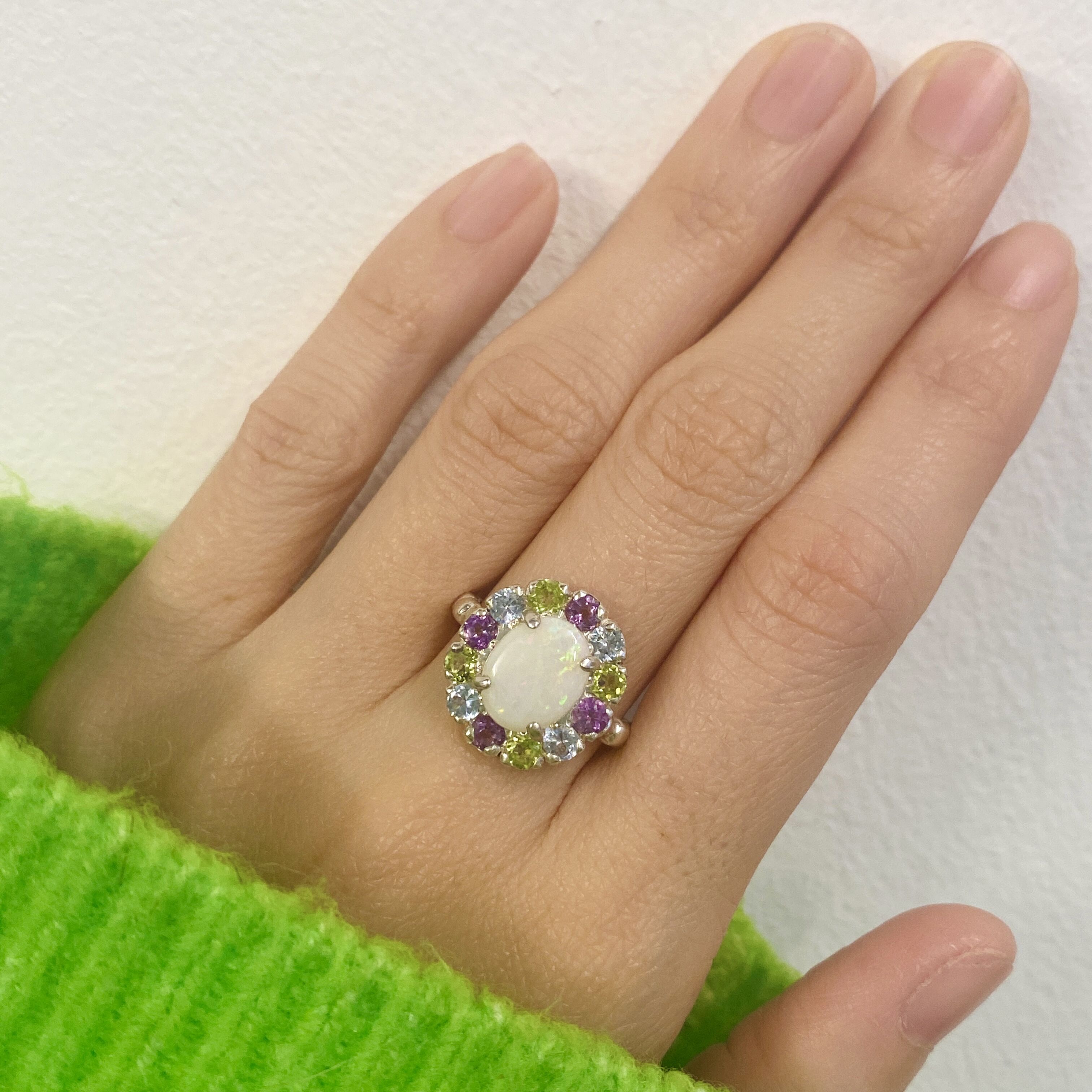 Flower Opal Ring styled for a cocktail look with nude nails and a cozy green sweater. The colorful cluster lifts mood and confidence. Ideal October birthstone gift for evening parties and holiday events.