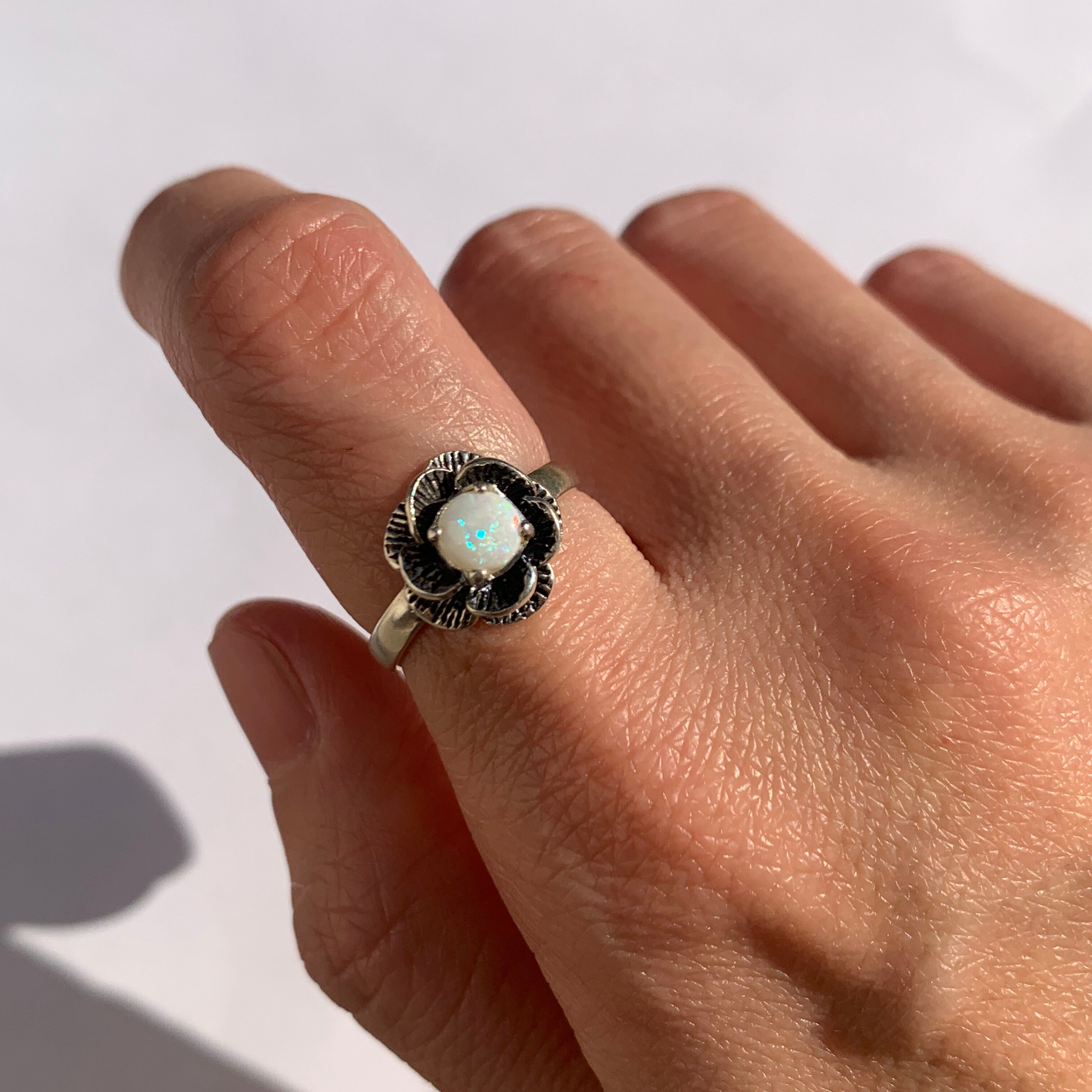 Flower Opal Ring worn on index finger with nude nails perfect for adding elegance and positive energy ideal for birthdays anniversaries or romantic evenings.
