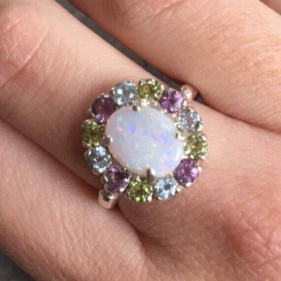 Flower Opal Ring worn on ring finger with nude nails. The colorful cluster gives joy and calm. A sweet October birthstone gift for weddings, brunch and date nights.