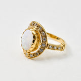 Australian Opal statement ring in gold with halo of CZ diamonds, featuring an oval cabochon gemstone, ideal for glamorous statement style, believed to inspire creativity and love, a perfect October birthstone gift for anniversaries, engagements, and elegant celebrations.