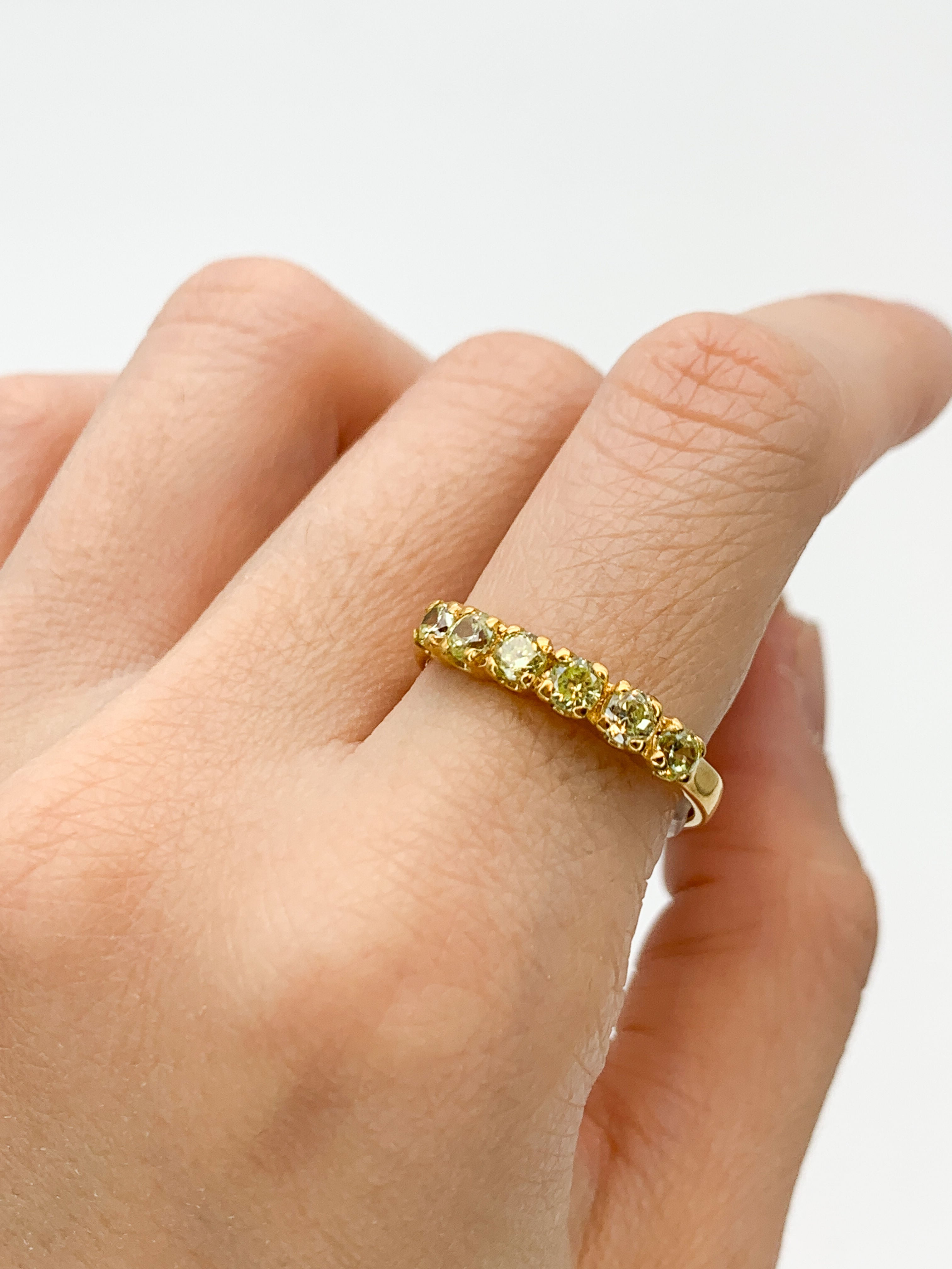 Gold peridot ring styled with natural skin tone and clean nails, perfect for both casual and elegant occasions, adding a touch of luxury and sparkle
