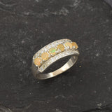 Opal Row Half Eternity Wide Ring in sterling silver featuring natural fire opals with flashes of fire colors, accented by CZ pave for a bold jewelry style. A meaningful October birthstone piece symbolizing balance and inspiration, making it a treasured gift idea. Perfect for weddings, anniversaries, cocktail events, and elegant evening occasions.