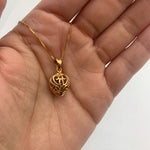 Heart charm necklace in 18k yellow gold over sterling silver, resting in an open palm - puffed heart pendant for size reference. 