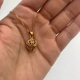 Heart charm necklace in 18k yellow gold over sterling silver, resting in an open palm - puffed heart pendant for size reference. 