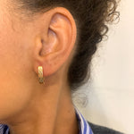 Woman wearing Hinged Hoop Earrings with Fishbone design, set in 18k Yellow Gold over solid 925 sterling silver, for casual wear.