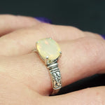 Ethiopian Fire Opal Sterling Silver Ring featuring a horizontal oval cut with a secure 4-prong setting. The engraved ornament band adds vintage charm, while the opal displays brilliant flashes of fire colors. A timeless October birthstone ring, perfect for birthdays, anniversaries, weddings, and milestone celebrations.