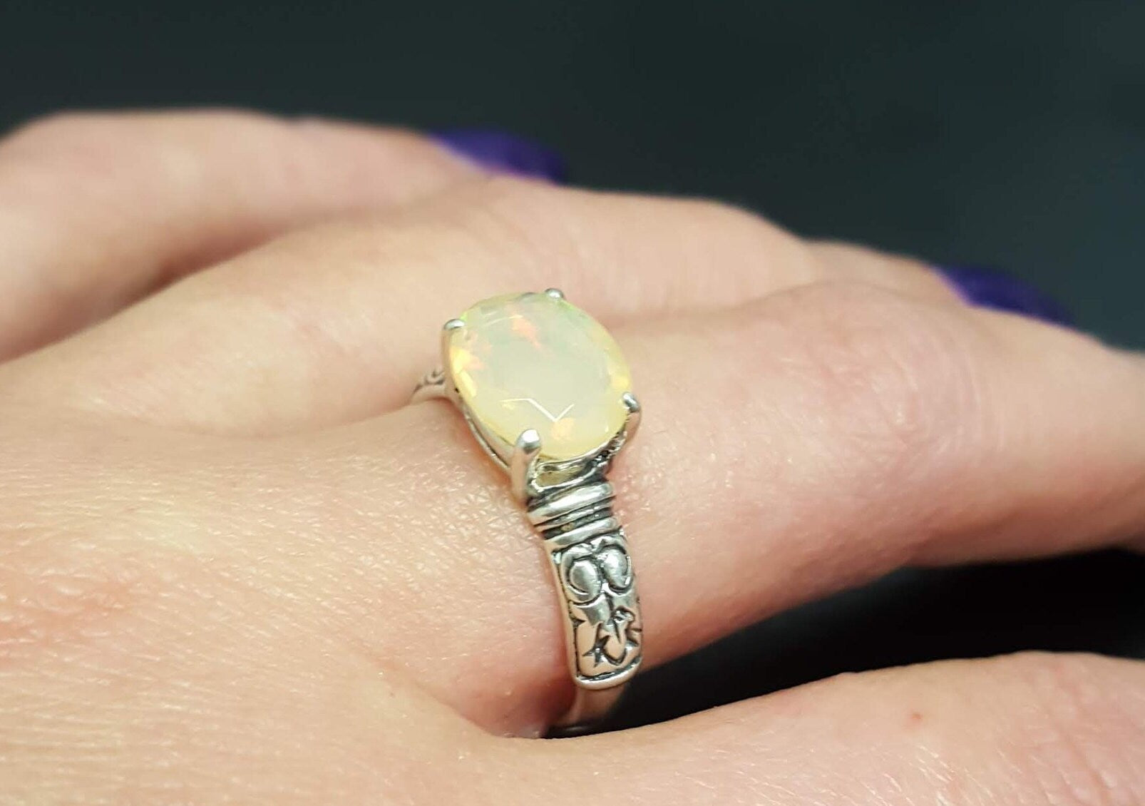 Ethiopian Fire Opal Sterling Silver Ring featuring a horizontal oval cut with a secure 4-prong setting. The engraved ornament band adds vintage charm, while the opal displays brilliant flashes of fire colors. A timeless October birthstone ring, perfect for birthdays, anniversaries, weddings, and milestone celebrations.