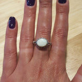 Horizontal Australian Opal Ring worn on middle finger with deep purple nails, white stone showing flashes of fire colors, stylish jewelry design that enhances confidence, symbolic October birthstone gift. Perfect for cocktail parties, evening dinners, and seasonal celebrations.