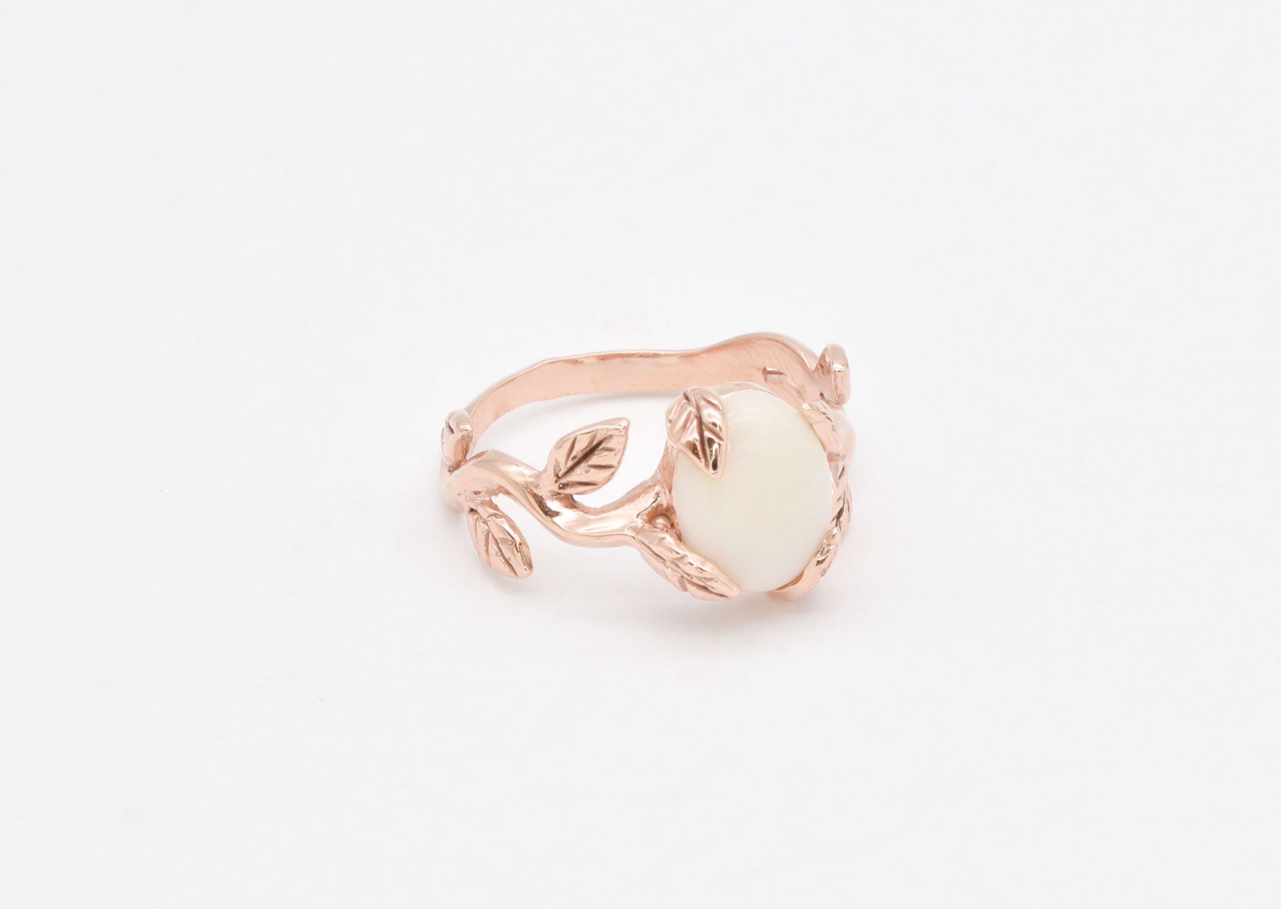 White Opal cabochon vine and leaf ring crafted in rose gold, featuring a nature-inspired design with flashes of fire colors. The durable vine-style band offers elegance and uniqueness while remaining comfortable for daily wear. As the October Birthstone, White Opal makes a thoughtful gift for birthdays, anniversaries, and nature lovers. Perfect to wear at weddings, outdoor celebrations, and festive gatherings.