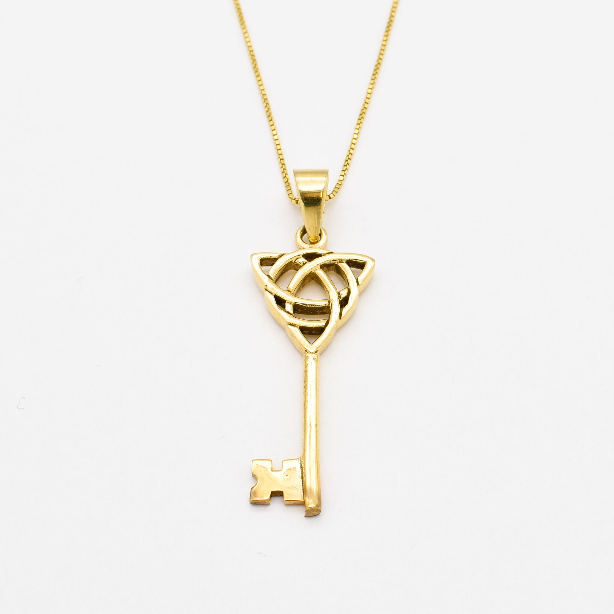 Long Key Pendant set in 18k Yellow Gold Vermeil over Solid 925 Sterling Silver. Gold Key Necklace with Trinity Knot, perfect as a statement necklace, can be styled with maximalist outfit. Trinity knot represents unity, eternal love, and the cycle of existence.