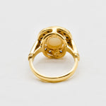 Australian Opal statement ring in gold with halo of CZ diamonds, featuring an oval cabochon gemstone, ideal for glamorous statement style, believed to inspire creativity and love, a perfect October birthstone gift for anniversaries, engagements, and elegant celebrations.