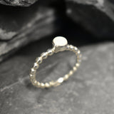 Australian White Opal bezel bubble band ring in sterling silver with round cabochon cut and flashes of fire colors, a chic jewelry style perfect for stacking and minimal elegance. Offers the benefit of a secure bezel set design with playful bubble band details, making it an ideal October birthstone gift. Perfect for birthdays, anniversaries, weddings, or everyday wear.