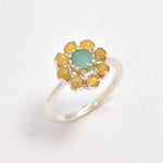Natural Emerald and Opal Flower Ring in sterling silver with round cabochon opals surrounding a central emerald. Jewelry style is elegant, floral, and artistic with a timeless silver band. Emerald is linked to growth, renewal, and love while Opal is believed to inspire creativity and balance. A meaningful May or Birthstone birthstone gift for birthdays, anniversaries, or special celebrations. Ideal for weddings, garden parties, formal gatherings, or daily elegance.