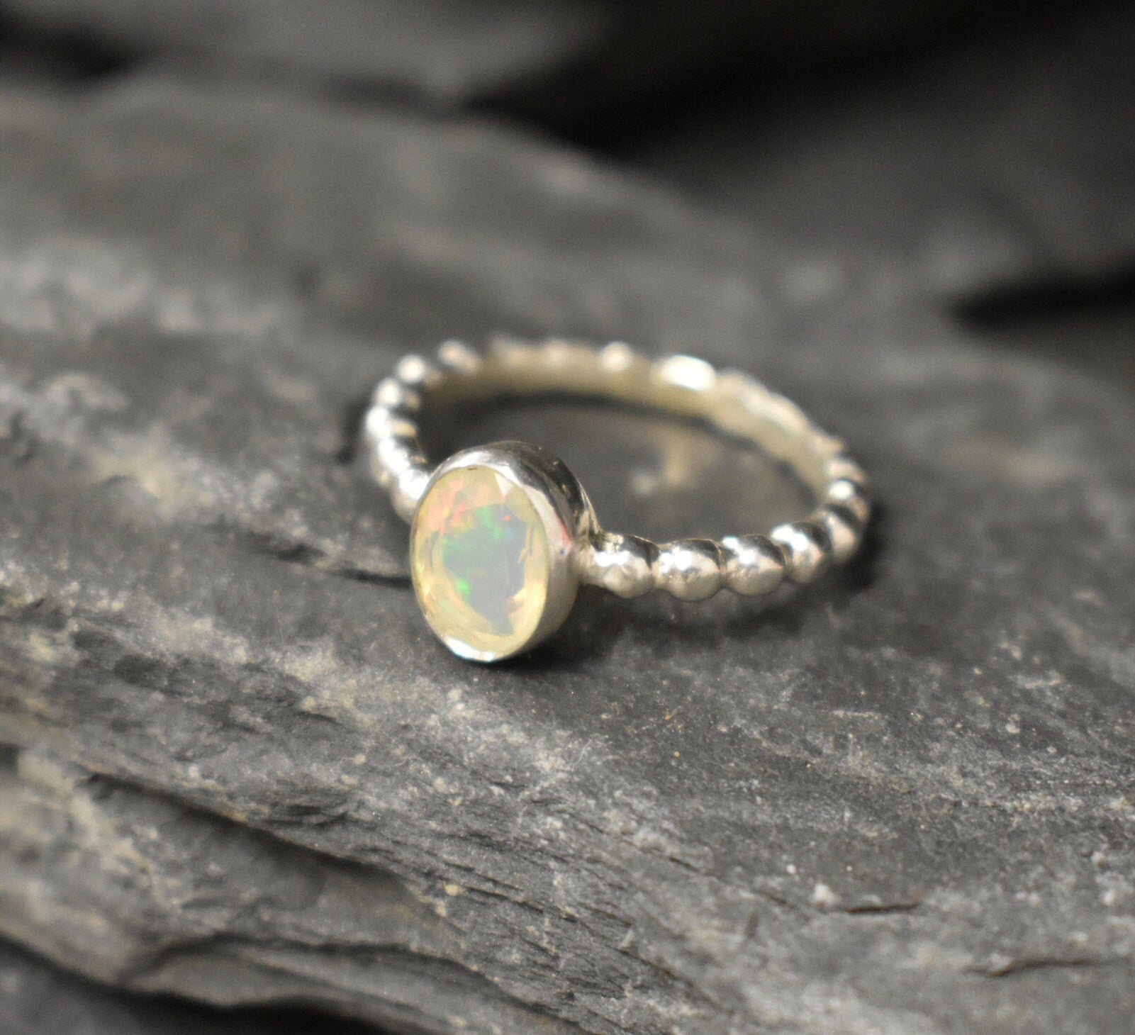 Fire Opal bezel bubble band ring in sterling silver with flashes of fire colors, a dainty jewelry style perfect for everyday elegance and stacking. Offers the benefit of durability with bezel setting and a glowing October birthstone gift idea for loved ones. Ideal to wear for birthdays, anniversaries, engagements, or casual celebrations.