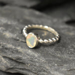 Fire Opal bezel bubble band ring in sterling silver with flashes of fire colors, a dainty jewelry style perfect for everyday elegance and stacking. Offers the benefit of durability with bezel setting and a glowing October birthstone gift idea for loved ones. Ideal to wear for birthdays, anniversaries, engagements, or casual celebrations.