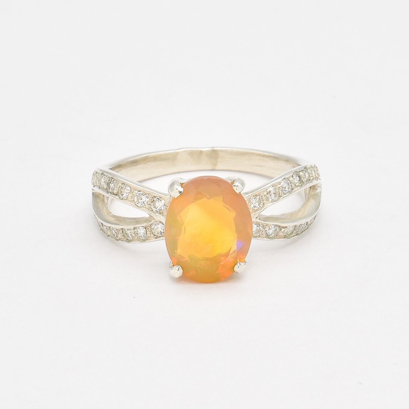Ethiopian Opal Oval Ring in sterling silver with a 4 prong setting and split shank design. Jewelry style features a CZ pave band that adds brilliance around the opal gemstone, glowing with flashes of fire colors. Opal is known for inspiring creativity, passion, and emotional balance. A meaningful October birthstone gift for birthdays, anniversaries, and special milestones. Perfect to wear at weddings, evening dinners, formal events, and cocktail parties.