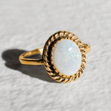 Natural Australian Opal gold ring with an oval cabochon cut gemstone framed by an intricate rope-edge design, offering a classic and elegant style. Opal, the October birthstone, is known for inspiring creativity and emotional harmony, making it an ideal gift for birthdays, anniversaries, weddings, or special celebrations.